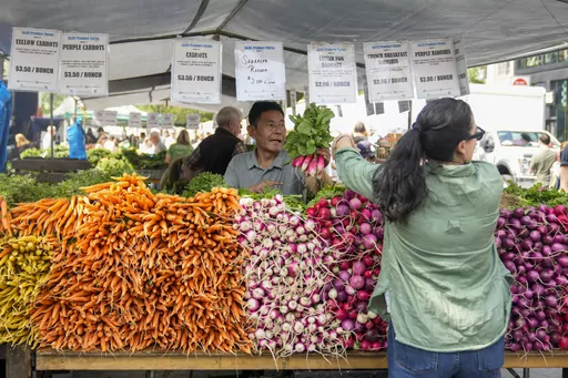A vendor helps a customer at a produce stand at the Union Square farmers market, Saturday, June 17, 2023, in New York. Small vendors at farmers markets say the 2023 season is shaping up to be strong, as farmers market continue to benefit from swells of regular customers that grew during the pandemic and new vendors stalls that started during the pandemic. (AP Photo/Mary Altaffer)