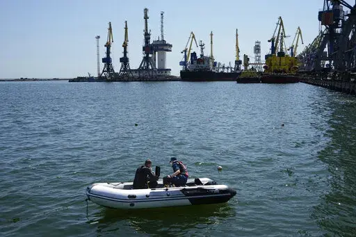 Servicemen of Donetsk People's Republic Emergency Ministry work to defuse a Ukrainian mine in an area of the Mariupol Sea Port in Mariupol, in territory under the government of the Donetsk People's Republic, eastern Ukraine, on April 29, 2022. This photo was taken during a trip organized by the Russian Ministry of Defense. The European Commission is proposing to help Ukraine move its critical grain supplies to parts of the world at risk of food insecurity. The plan released Thursday, May 12, 202