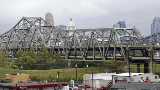 Traffic on the Brent Spence Bridge passes in front of the Cincinnati skyline while crossing the Ohio River to and from Covington, Ky., Oct. 7, 2014. According to a recent announcement by Kentucky and Ohio they will receive more than $1.63 billion in federal grants to help build a new Ohio River bridge near Cincinnati and improve the existing overloaded span there, a heavily used freight route linking the Midwest and the South. (AP Photo/Al Behrman, File)