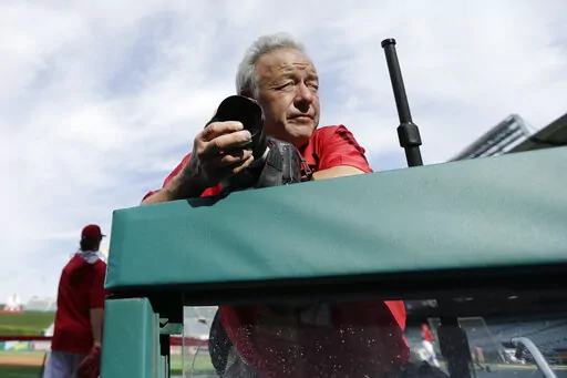 Photographer Lenny Ignelzi leans against a dugout rail Oct. 3, 2014, before Game 2 of baseball's AL Division Series between the Los Angeles Angels of Anaheim and the Kansas City Royals in Anaheim, Calif. Ignelzi, whose knack for being in the right place at the right time produced breathtaking images of Hall of Fame sports figures, devastating wildfires and other major news over 37 years as photographer for The Associated Press in San Diego, has died. He was 74. Ignelzi died Friday, April 29, 202